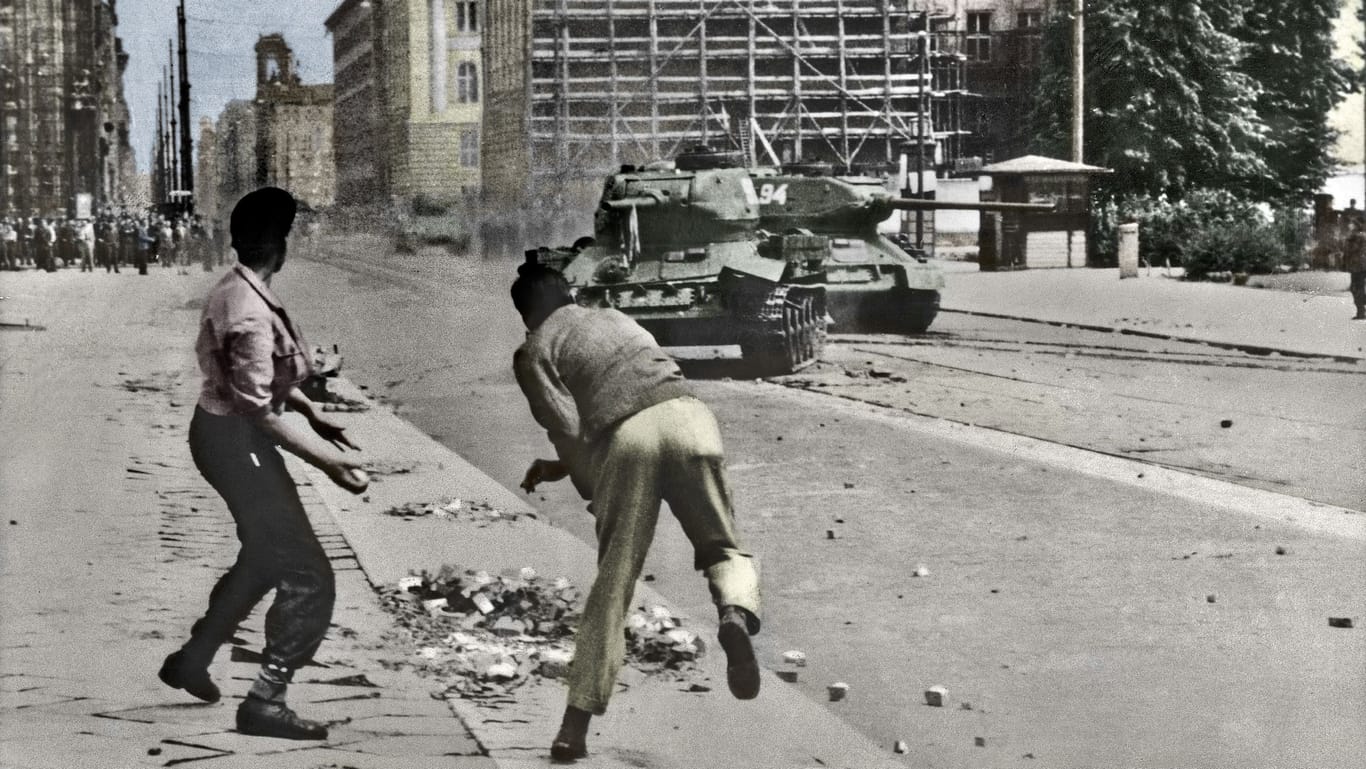 Aufstand in der DDR (nachträglich koloriertes Foto): Jugendliche bewerfen Panzer mit Steinen.