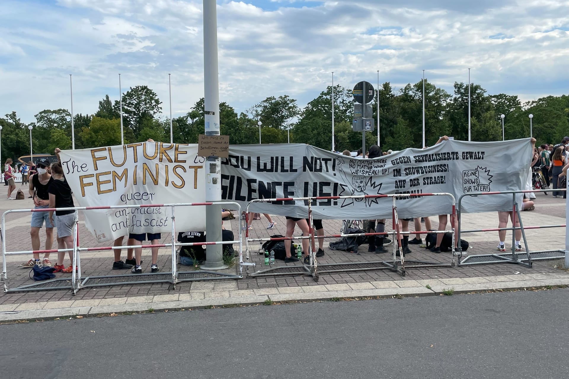 Teilnehmer der Demonstration halten Transparente hoch: Unter anderem "Gegen sexualisierte Gewalt im Showbusiness" steht darauf.