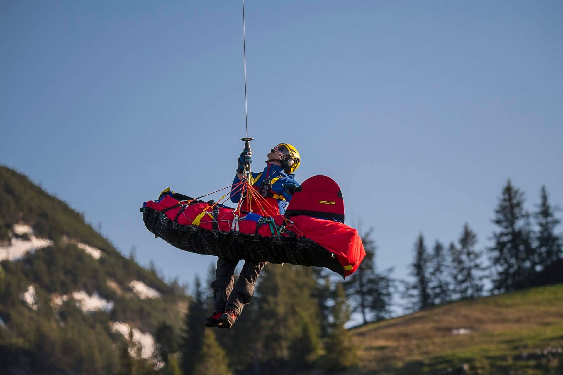 Ein Retter der Bergwacht in Bayern hängt an einem Seil (Archivbild): Bei ihren Einsätzen erleben sie jährlich zwei bis fünf Todesfälle.