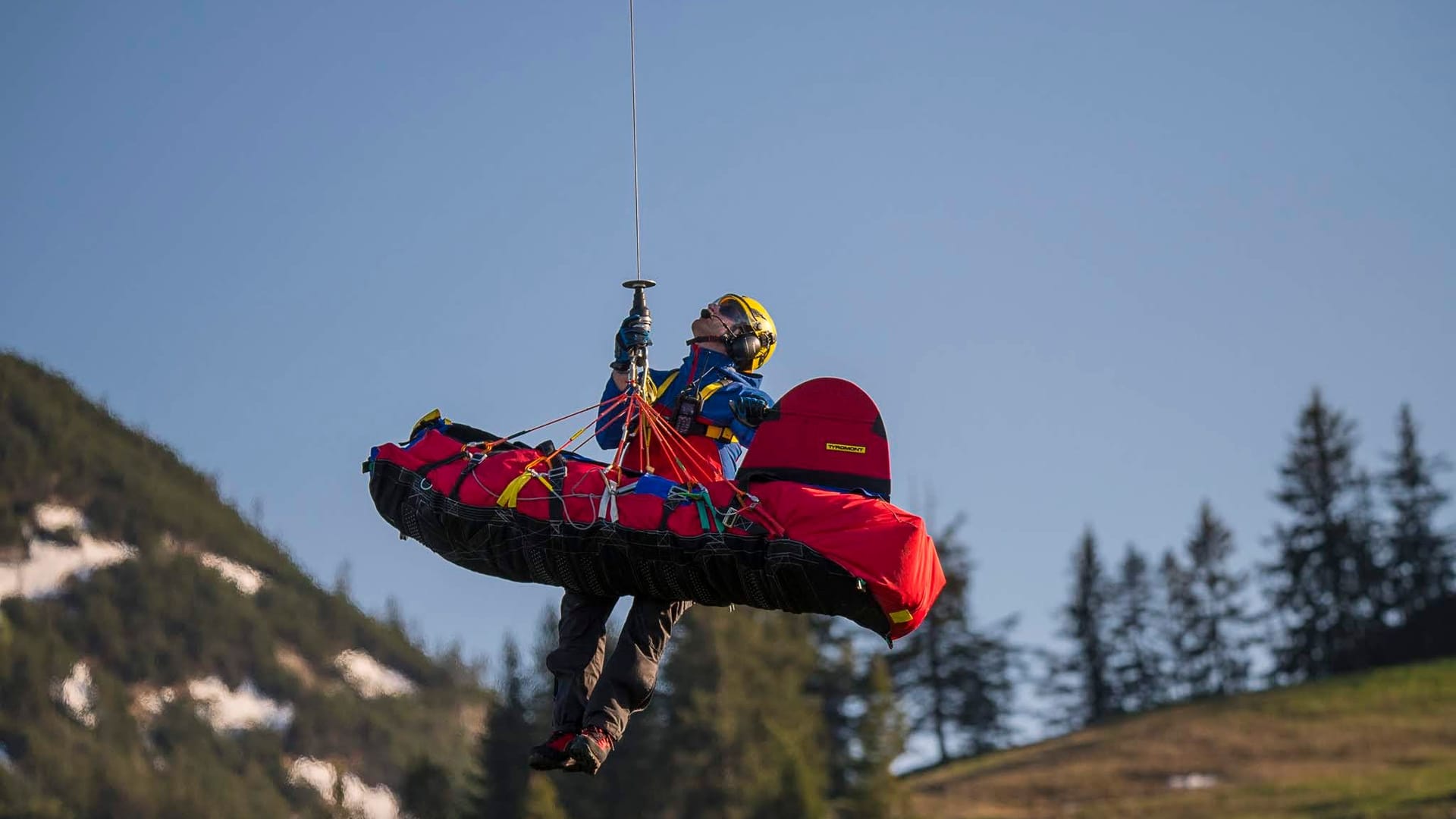 Ein Retter der Bergwacht in Bayern hängt an einem Seil (Archivbild): Bei ihren Einsätzen erleben sie jährlich zwei bis fünf Todesfälle.