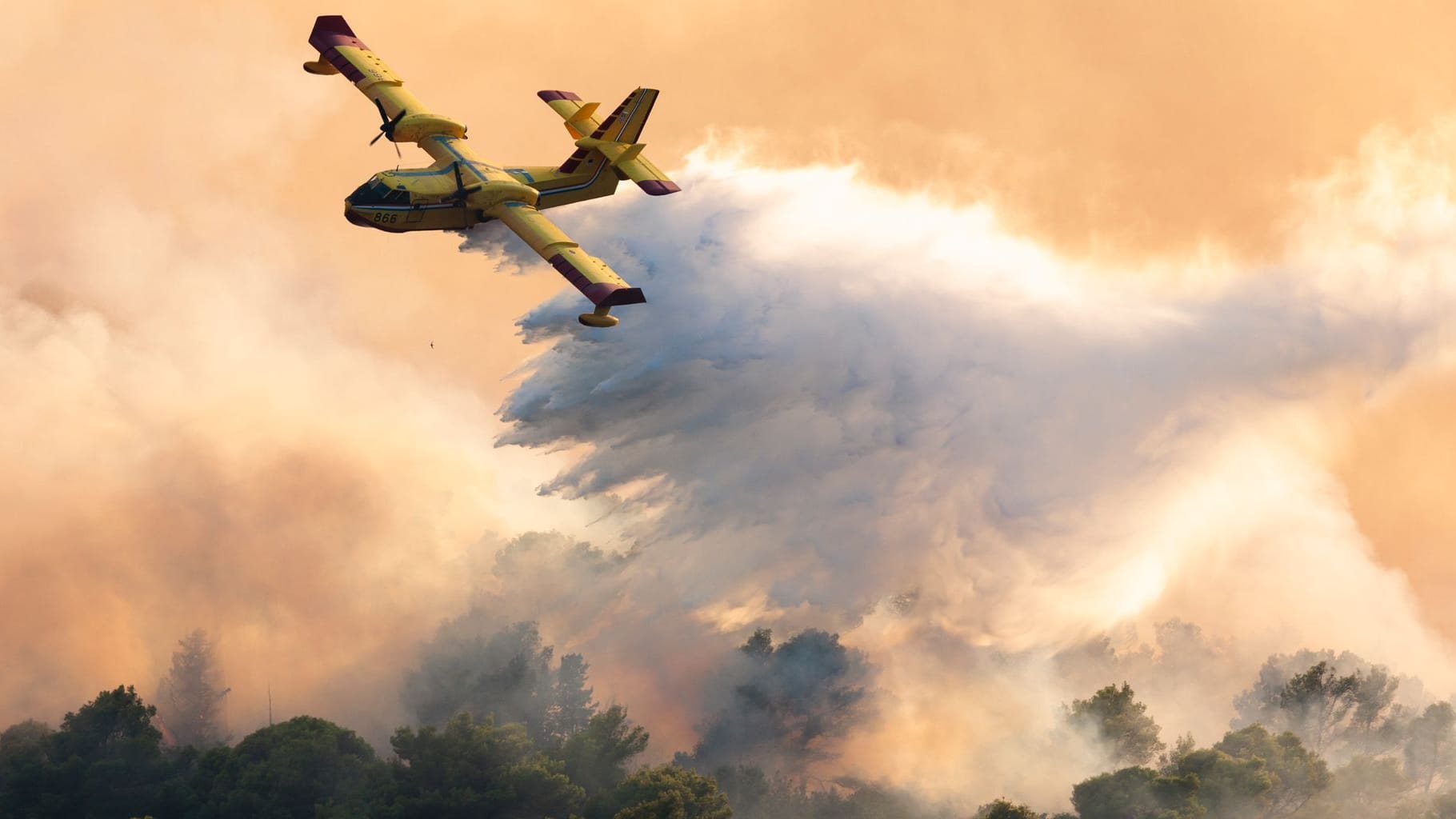 Kroatien, Ciovo: Ein Löschflugzeug versprüht Wasser, um einen Waldbrand auf der Insel Ciovo zu löschen.