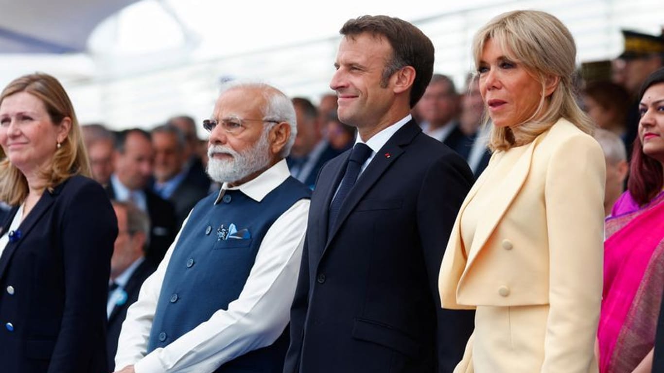 Narendra Modi (l), Premierminister von Indien, Emmanuel Macron, Präsident von Frankreich, und seine Ehefrau First Lady Brigitte Macron: Modi ist in diesem Jahr Ehrengast der Parade.