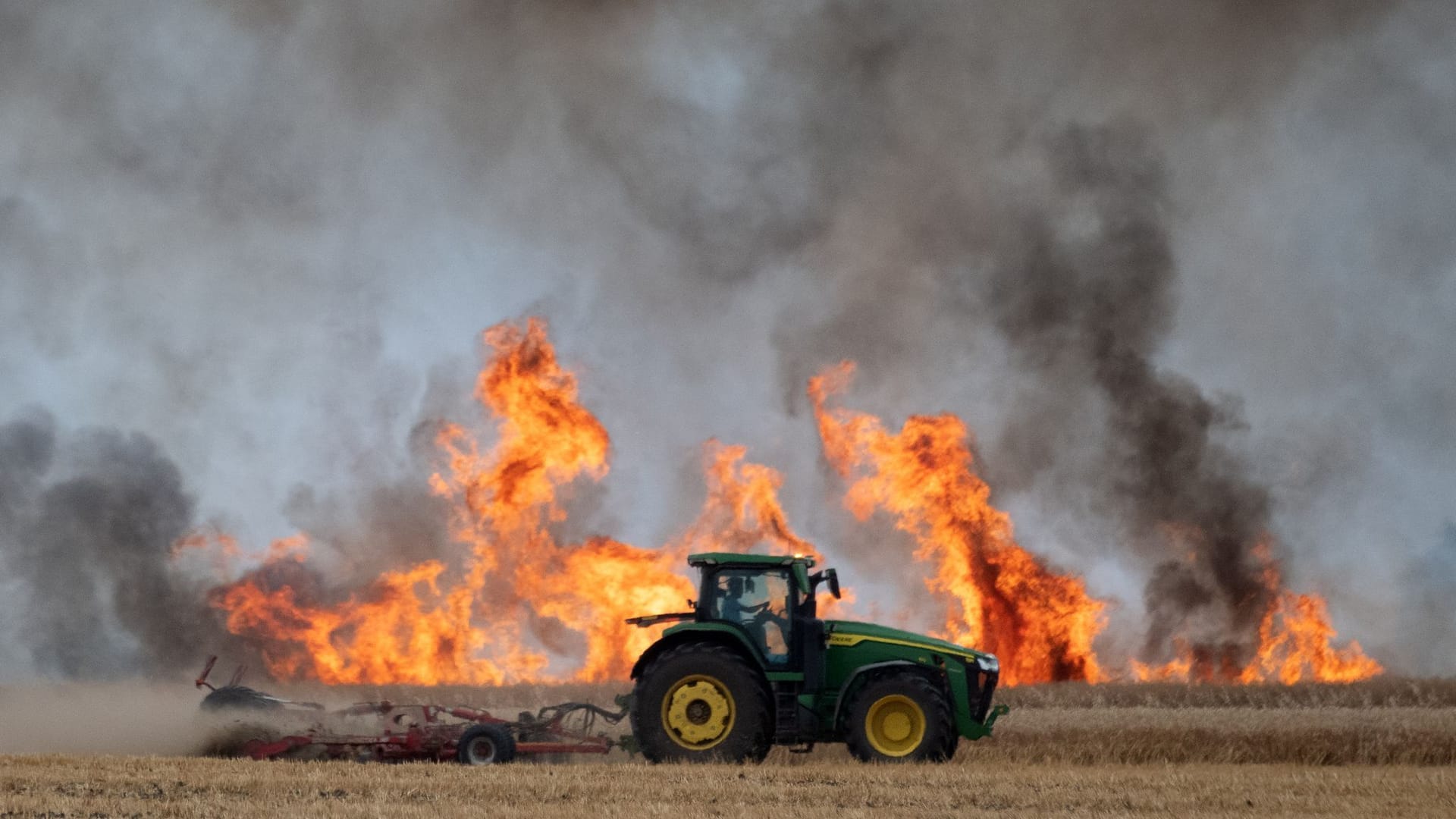 Dunkle Rauchwolken steigen bei einem Feldbrand nahe Leipzig auf: Die Landwirte versuchen alles, um die Flammen einzudämmen.