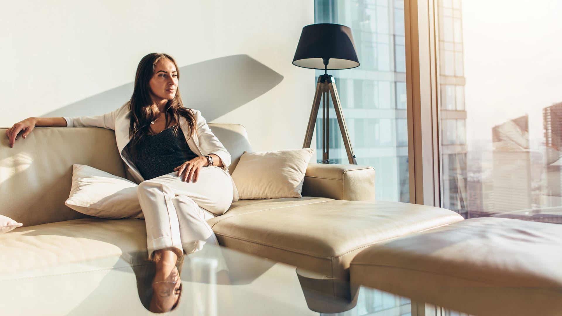 Elegant gekleidete Frau sitzt in ihrer Wohnung (Symbolbild): Ab wann man in Deutschland als reich gilt, ist nicht klar definiert.