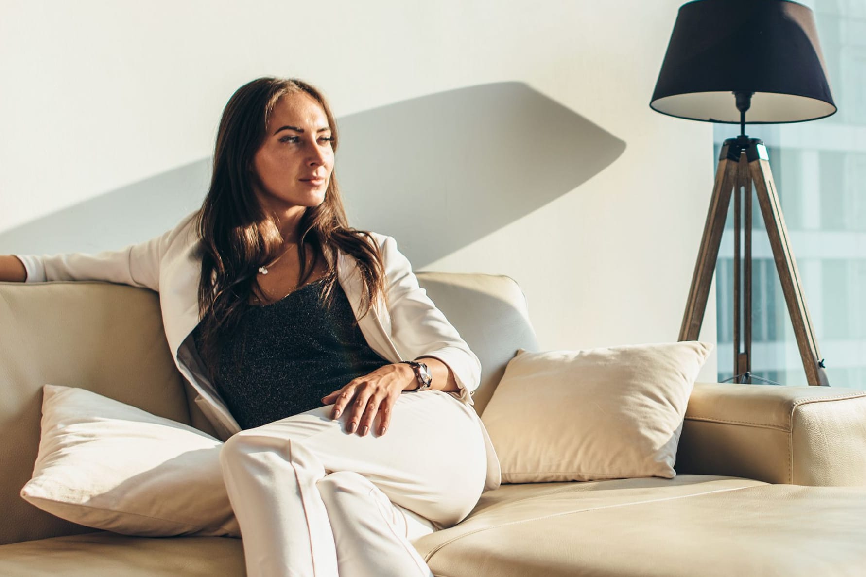 Elegant gekleidete Frau sitzt in ihrer Wohnung (Symbolbild): Ab wann man in Deutschland als reich gilt, ist nicht klar definiert.