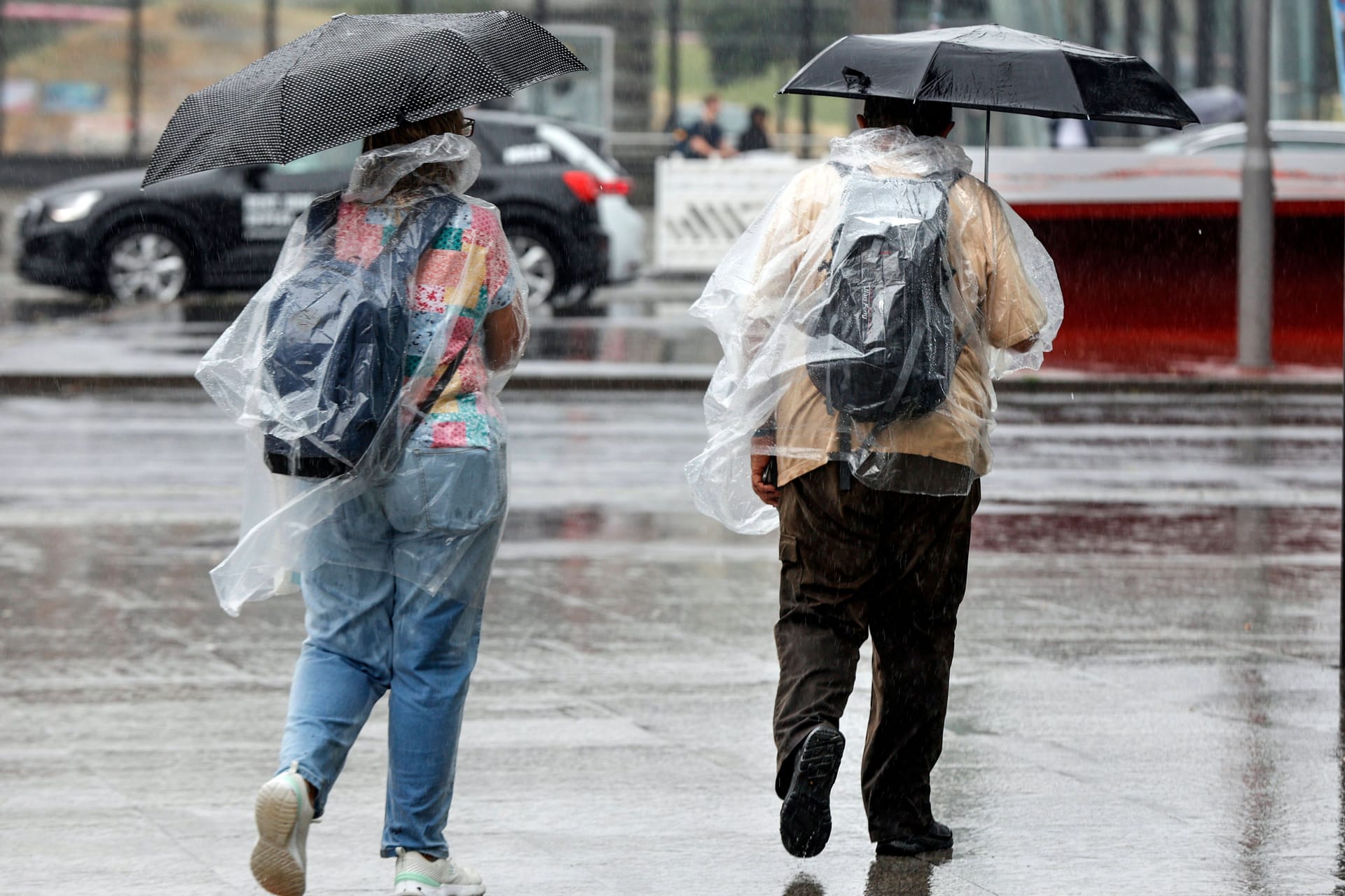 Personen mit Regenschirmen (Archivbild): In Berlin und Brandenburg wird es ungemütlich.