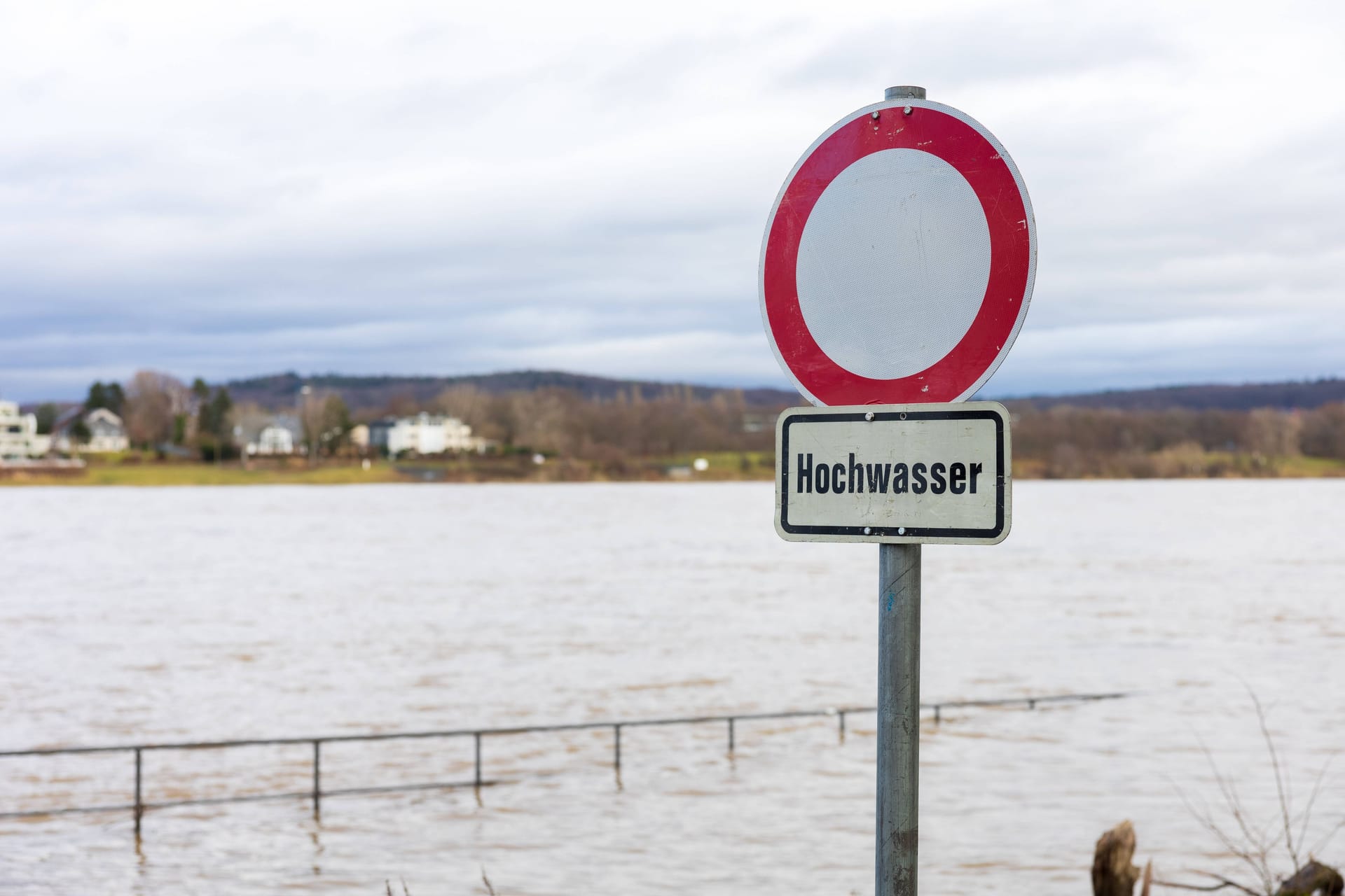 Bonn: Ein temporär aufgestelltes Schild am Rheinufer warnt vor überfluteten Fußgänger und Fahrrad-Wegen.