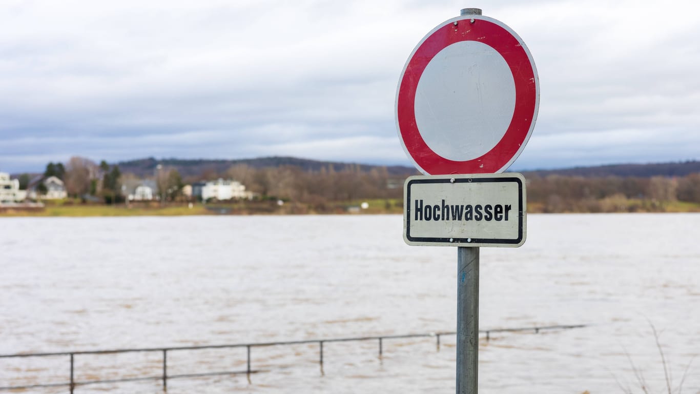 Bonn: Ein temporär aufgestelltes Schild am Rheinufer warnt vor überfluteten Fußgänger und Fahrrad-Wegen.
