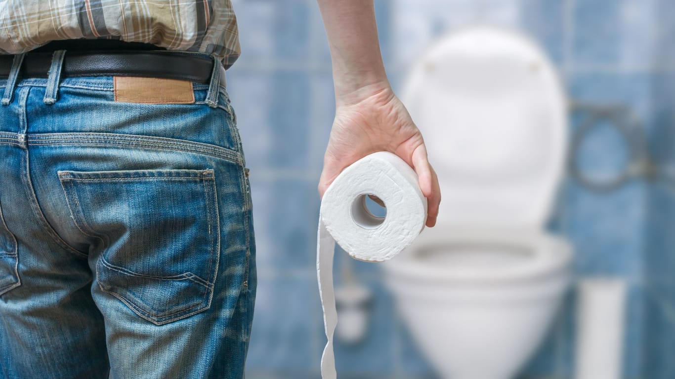 Mann hält Toilettenpapier (Symbolbild): Der Aufenthalt auf dem WC am Arbeitsplatz ist rein privater Natur. Das hat Auswirkungen auf die Unfallversicherung.