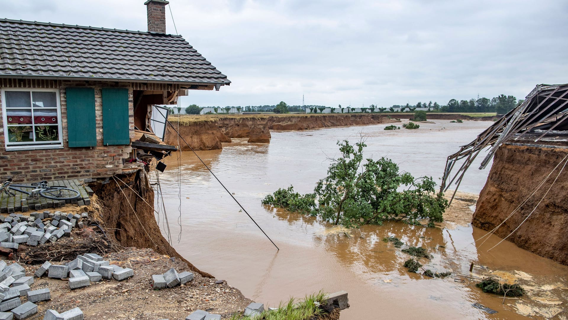 Starkregen, Überschwemmungen und Fluten: Nach Einschätzung des Deutsches Wetterdienstes werden Wetterextreme wie diese mit der anhaltenden Erderwärmung weiter zunehmen. Im Juli 2021 etwa kam es in Teilen Deutschlands zu heftigen Unwettern. Am schlimmsten waren Nordrhein-Westfalen und Rheinland-Pfalz betroffen: Dort starben mehr als 190 Menschen. Die Flut verursachte zudem Sachschäden in Milliardenhöhe. (Hier zu sehen: die Abbruchkante bei der Flutkatastrophe in Erftstadt im Sommer 2021.)