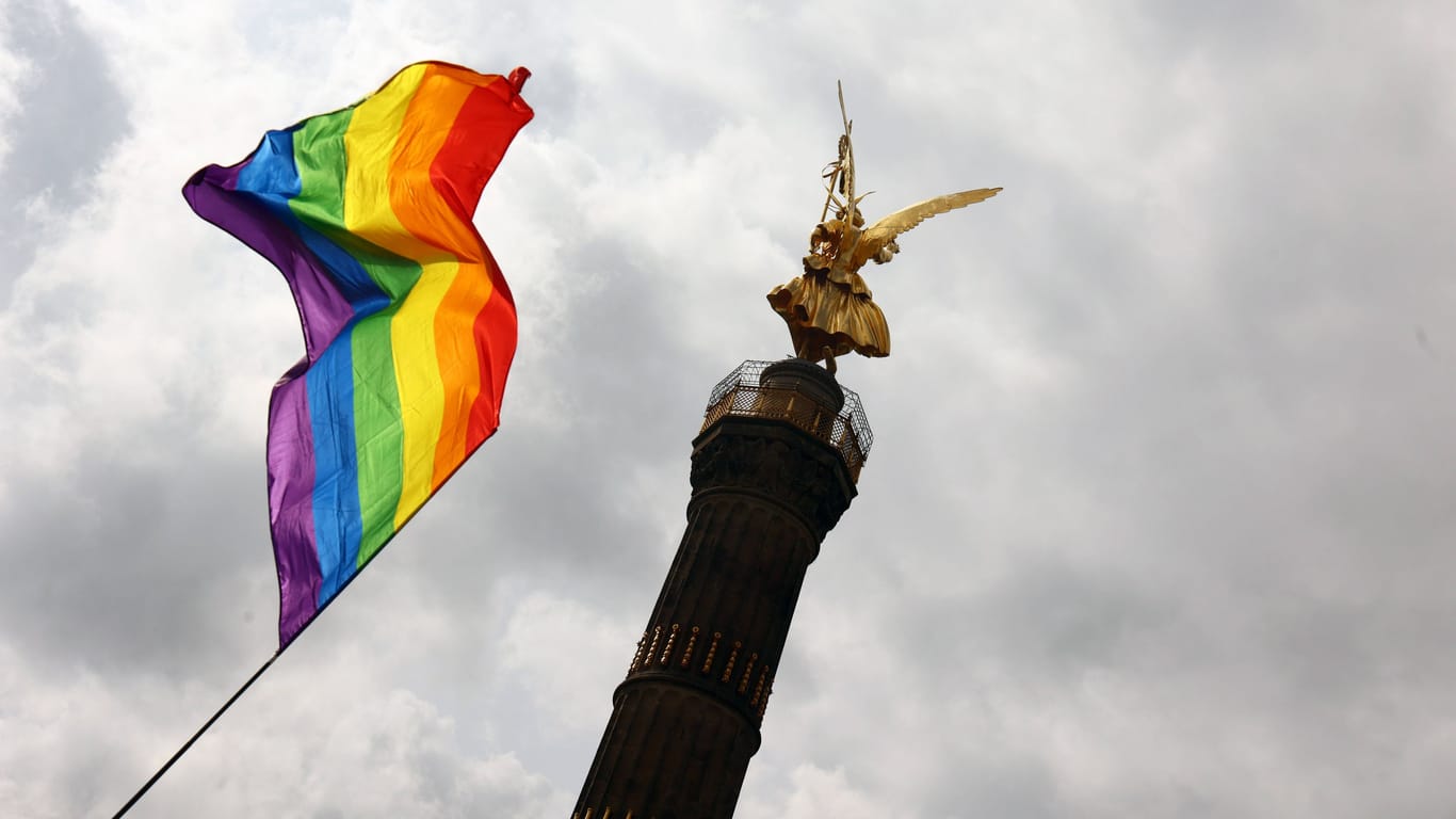Während des Christopher-Street-Days 2023 in Berlin weht eine Regenbogenfahne vor der Siegessäule am Großen Stern