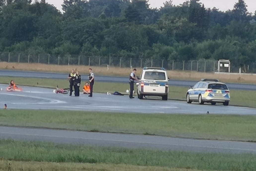 Blockade in Hamburg: Drei Aktivisten haben sich auf dem Rollfeld festgeklebt.