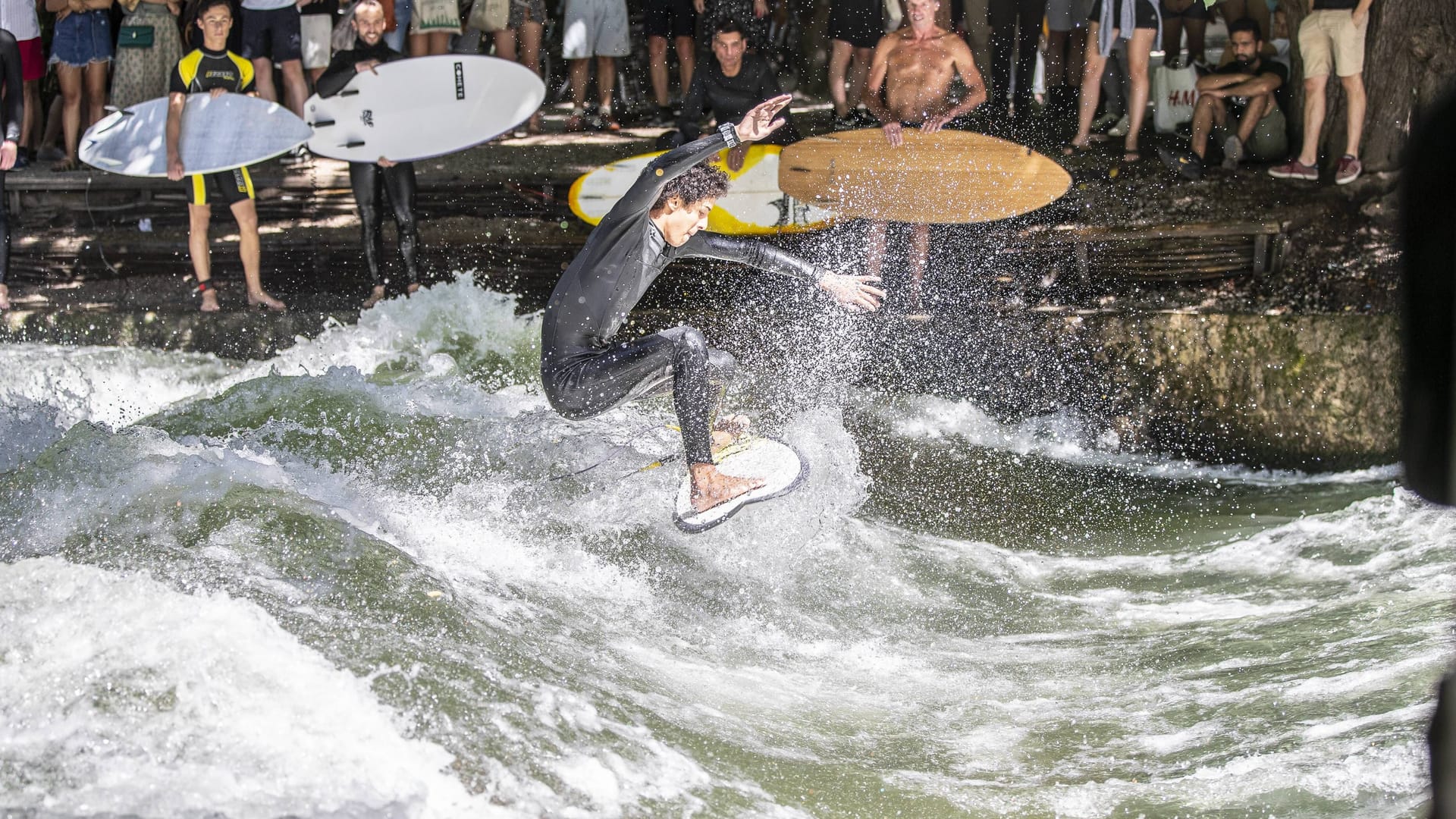 Ein Surfer auf der Eisbachwelle in München (Archivbild): In der bayerischen Landeshauptstadt wurde des Surfen am Festland erfunden.