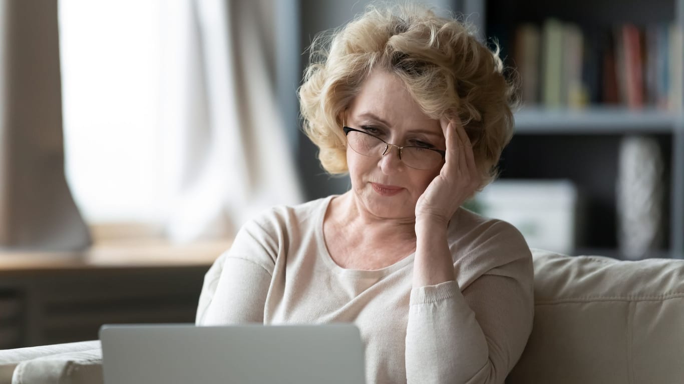 Ältere Frau blickt besorgt auf ihr Laptop: Frauen erhalten im Schnitt deutlich weniger Altersrente als Männer.