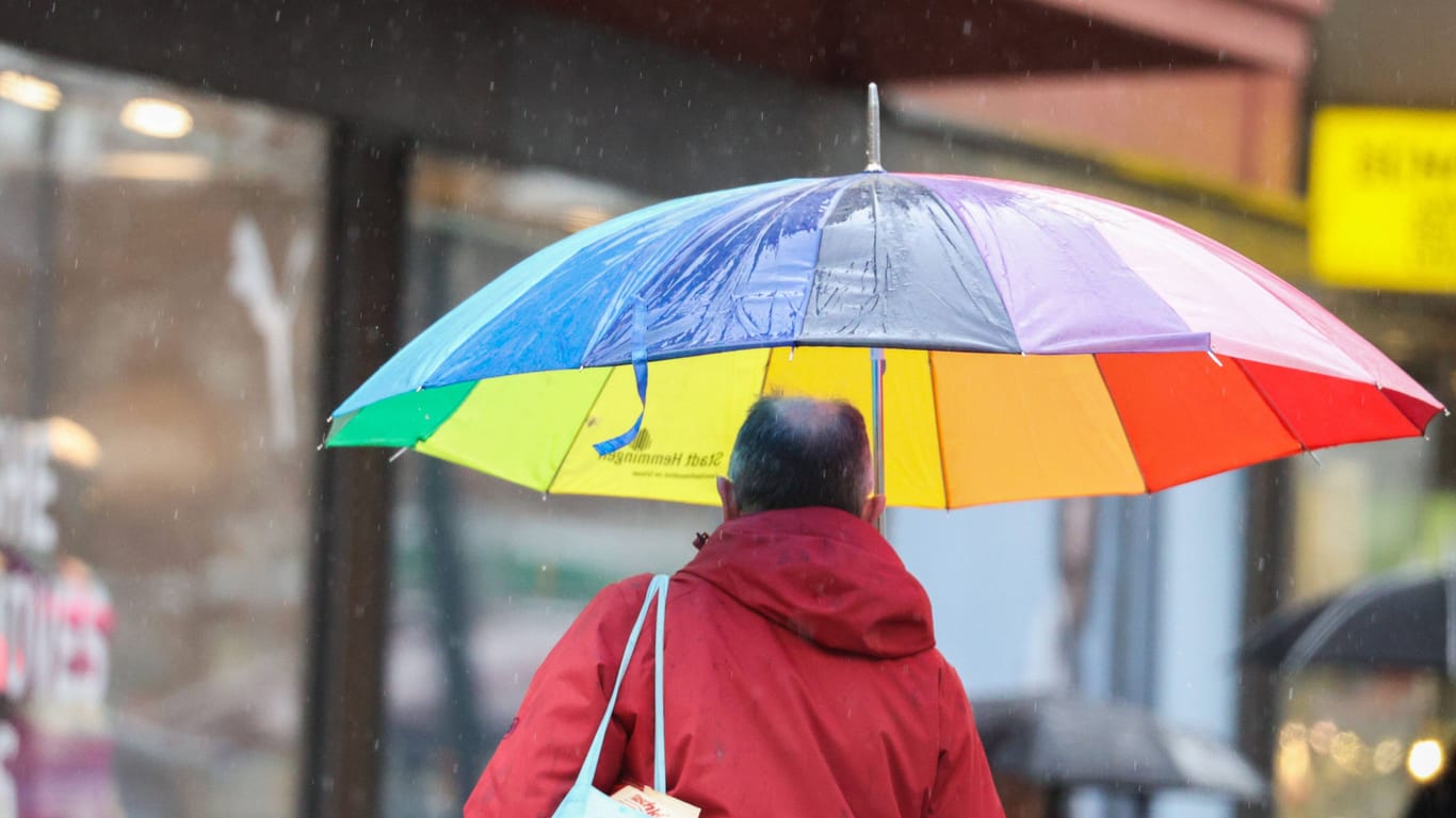 Ein Mann läuft unter einem Regenschirm durch Hannover (Symbolbild): Die neue Woche startet mit Regen, vereinzelt sind auch Gewitter möglich.