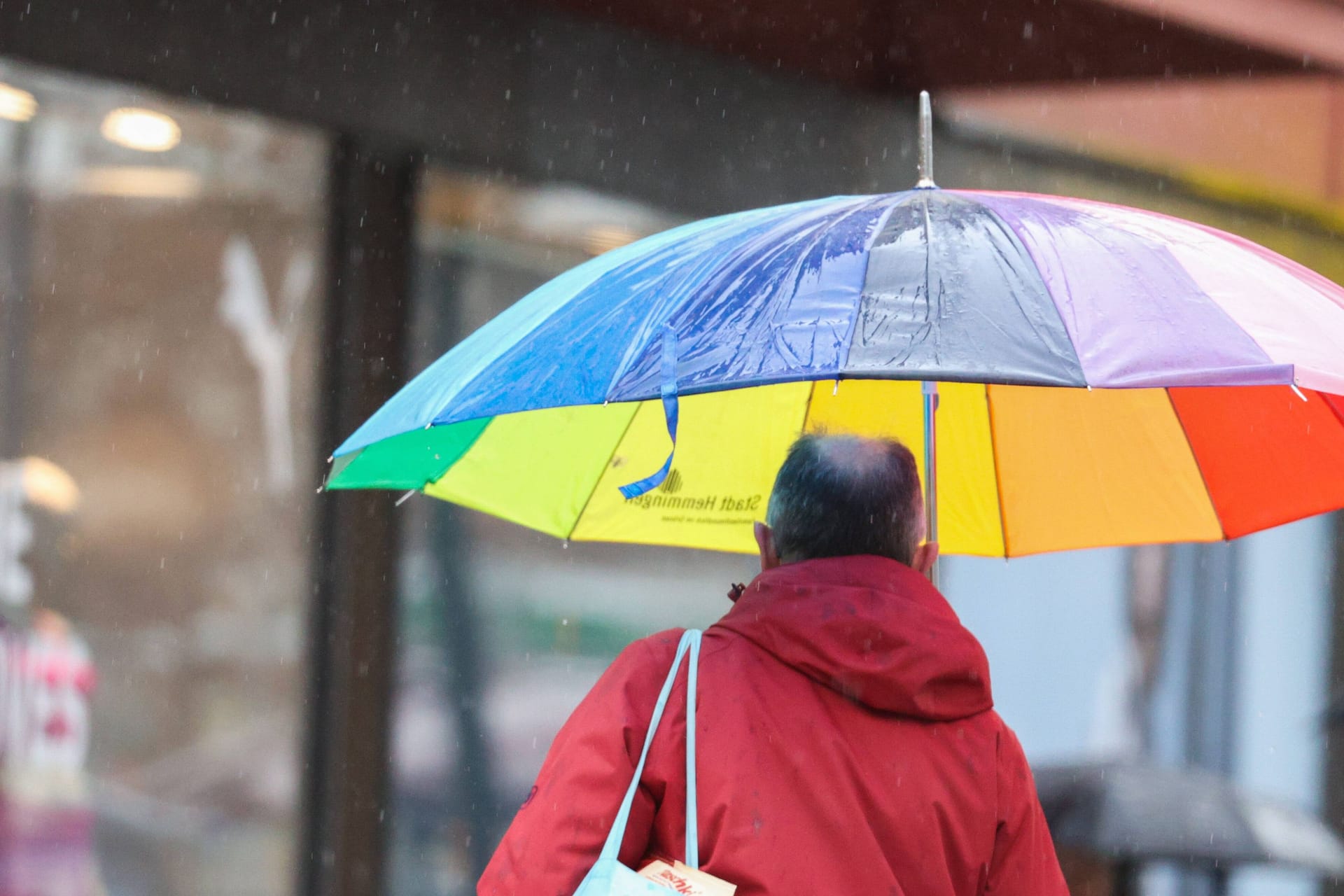 Ein Mann läuft unter einem Regenschirm durch Hannover (Symbolbild): Die neue Woche startet mit Regen, vereinzelt sind auch Gewitter möglich.