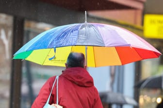 Ein Mann läuft unter einem Regenschirm durch Hannover (Symbolbild): Die neue Woche startet mit Regen, vereinzelt sind auch Gewitter möglich.
