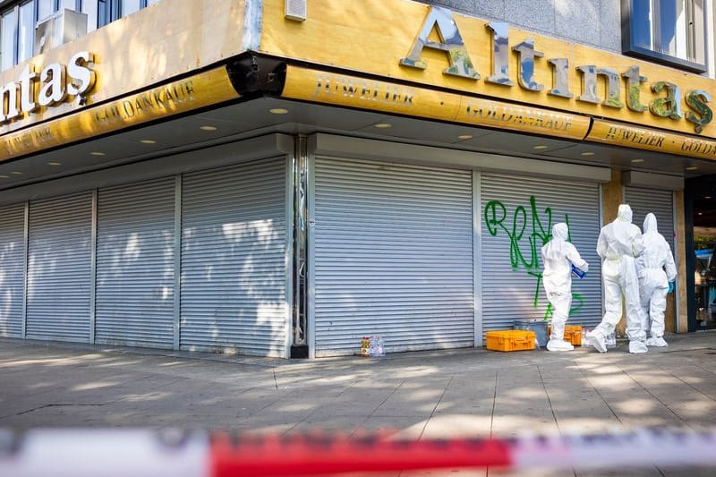 Mitarbeiter der Spurensicherung stehen vor dem Juwelier in der Innenstadt. Von den Tätern fehlt jede Spur.