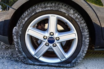 Platter Reifen an einem Auto (Symbolbild): Die Polizei hat ein Bekennschreiben gefunden.