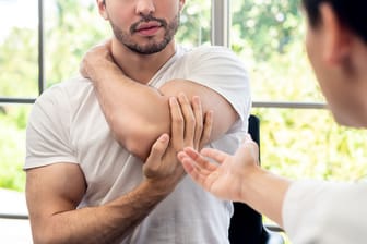 Mann erzählt Arzt von Schmerzen im Arm