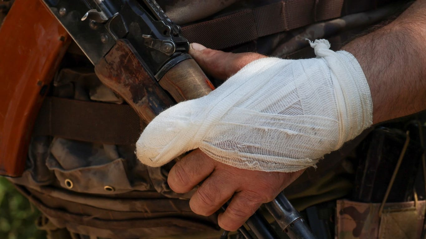 Ein ukrainischer Soldat hält mit bandagierter Hand sein Maschinengewehr bei einer Übung in der Region Donezk.