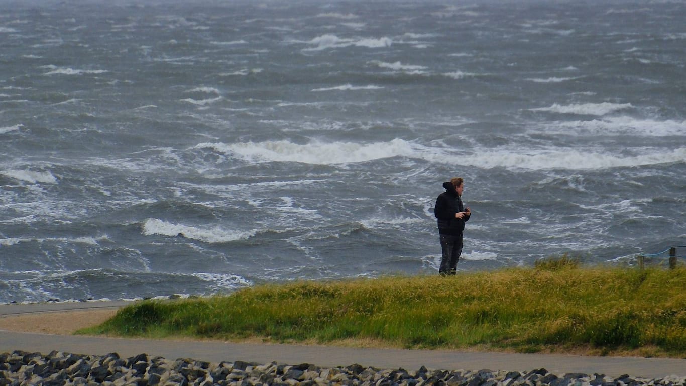Eine Person steht bei Sturm an der Nordeseeküste (Symbolbild): Zum Ende der Woche wird es noch einmal ungemütlich im Norden.