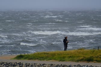 Eine Person steht bei Sturm an der Nordeseeküste (Symbolbild): Zum Ende der Woche wird es noch einmal ungemütlich im Norden.