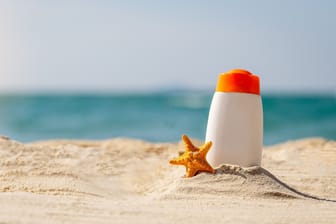 Eine Flasche Sonnencreme am Strand