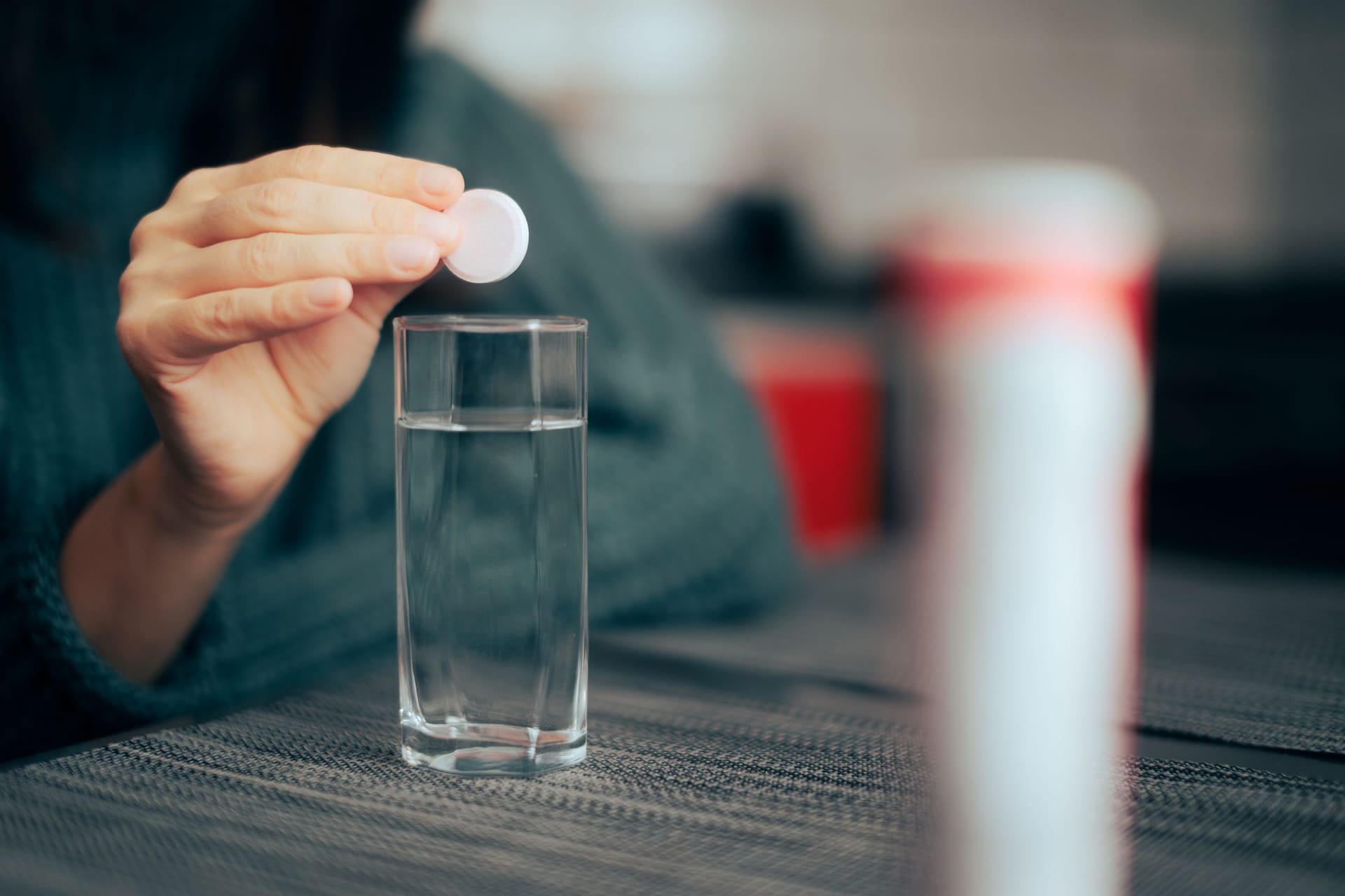 Frau lässt Brausetablette in ein Glas fallen