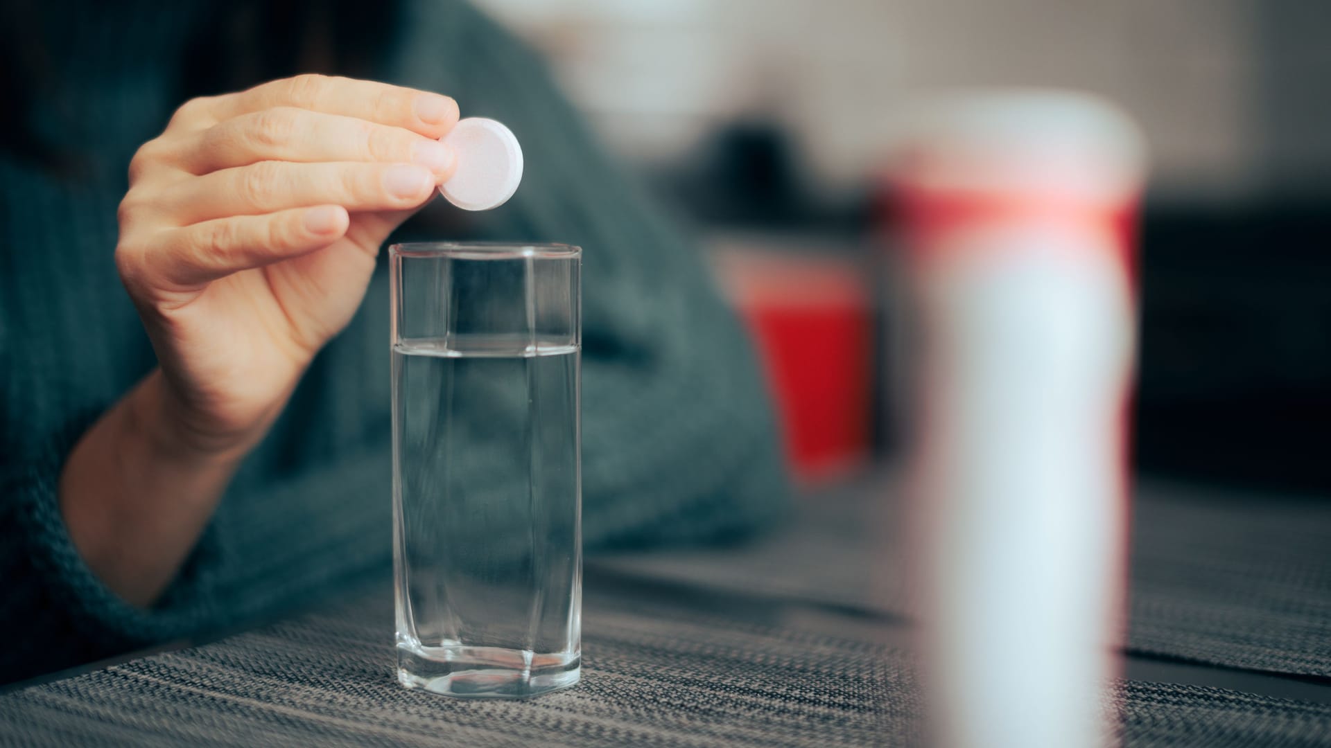 Frau lässt Brausetablette in ein Glas fallen