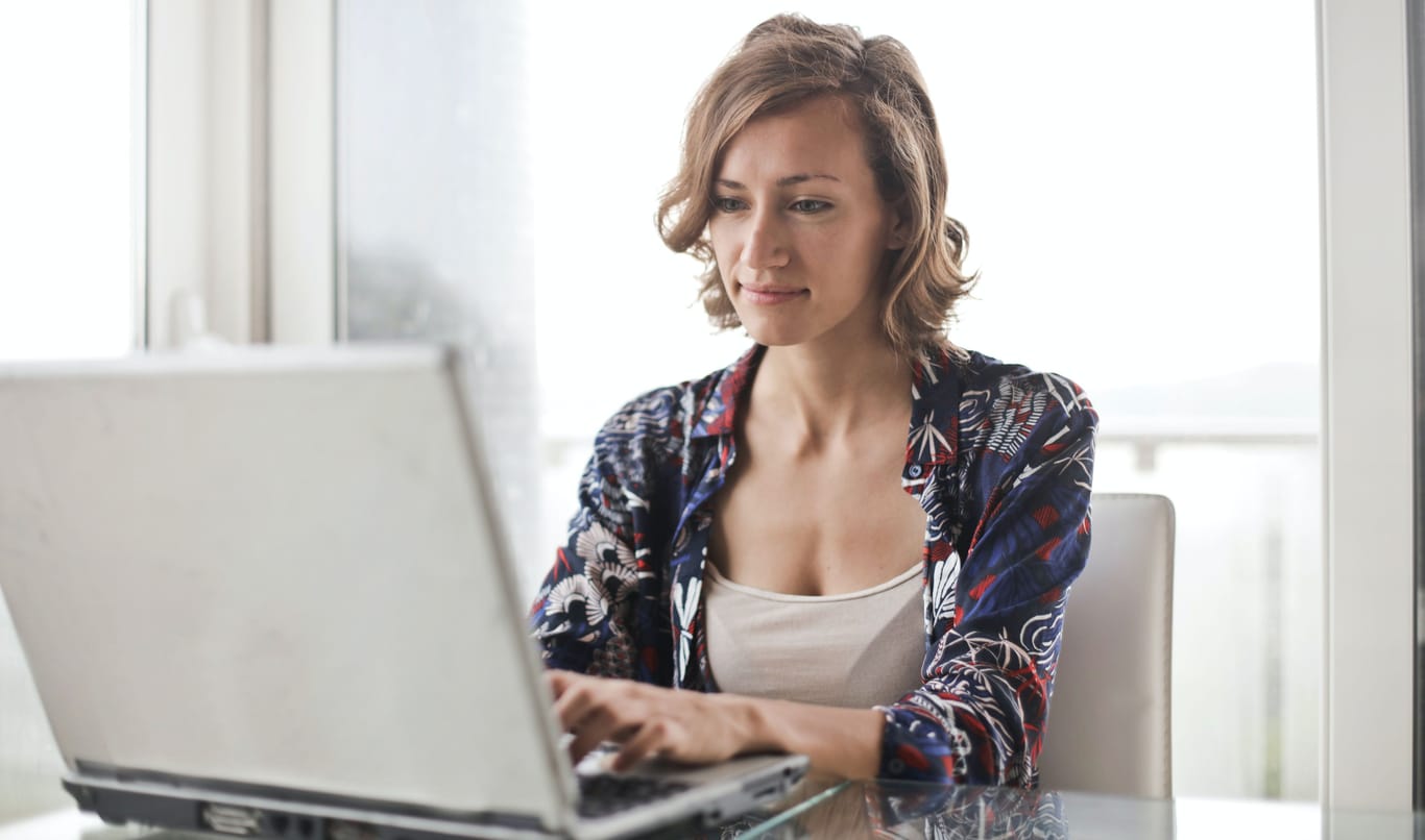 Eine Frau am Laptop: Online shoppen kann bequem sein. Allerdings sollten Sie vor einem Kauf die Internetseite auf Echtheit prüfen.