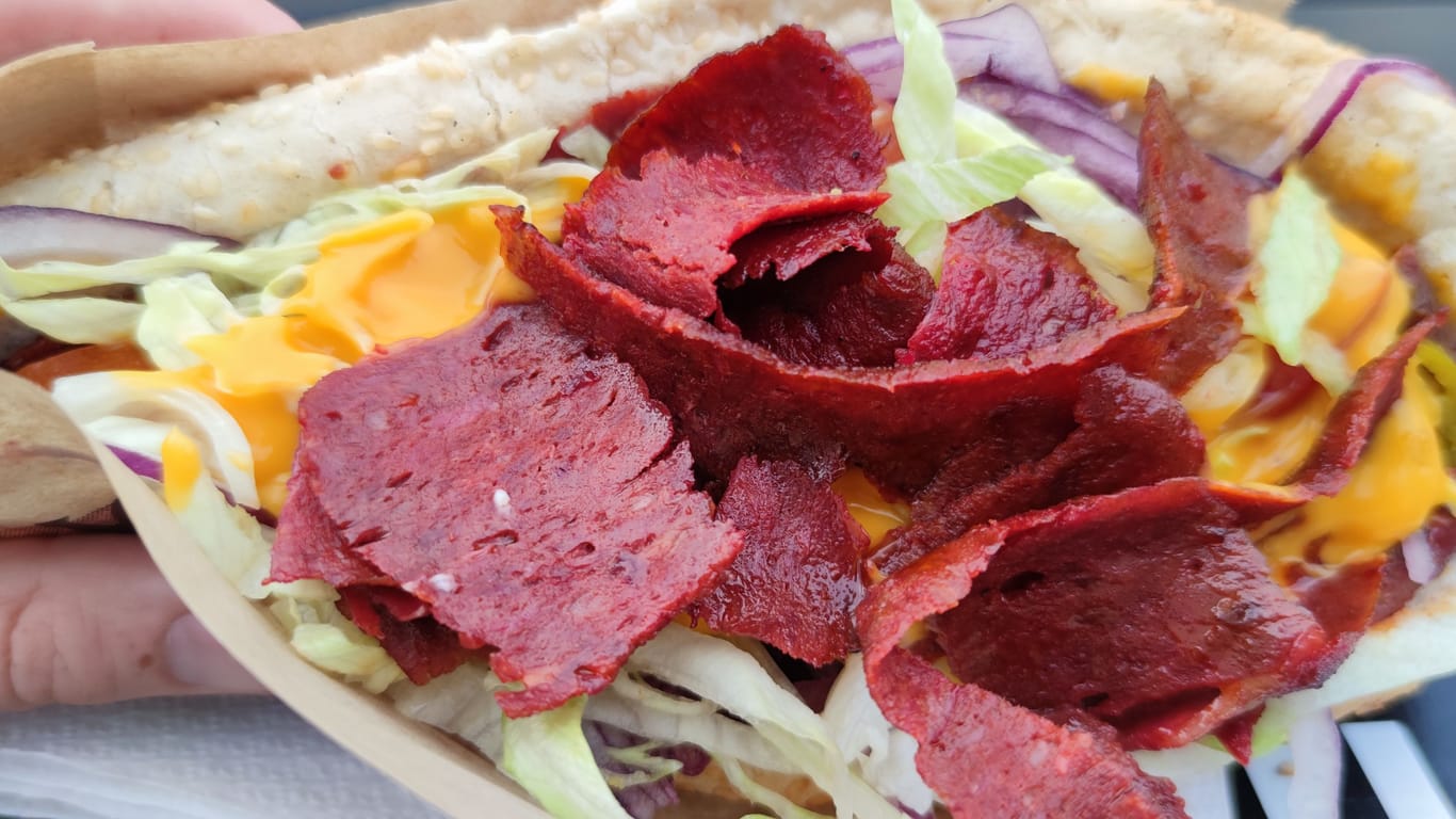 "Söner"-Sandwich in der Hand: Hier kommt Knoblauchwurst ins Brot.