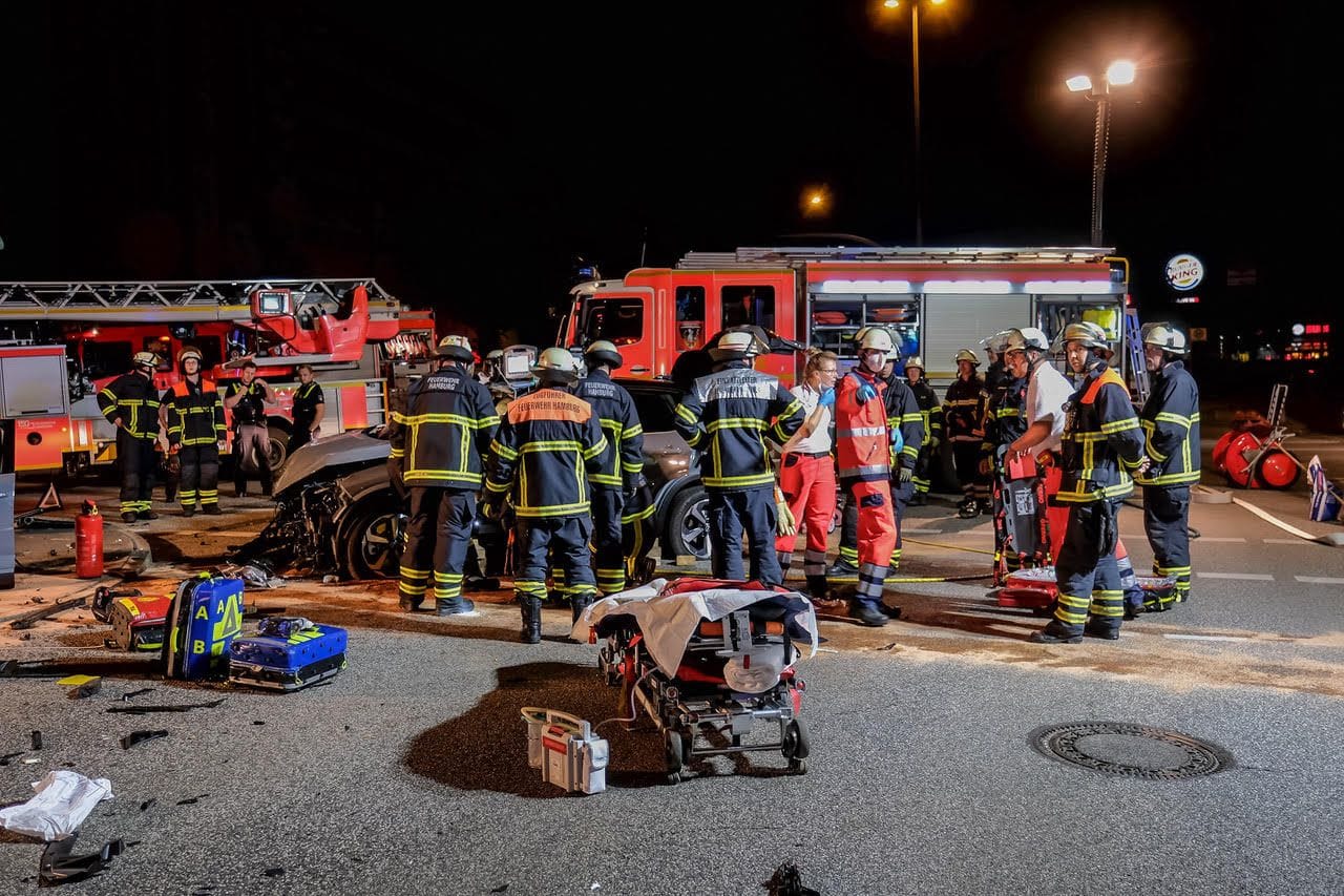 Die Retter befreien die Frau aus ihrem zerstörten Auto.