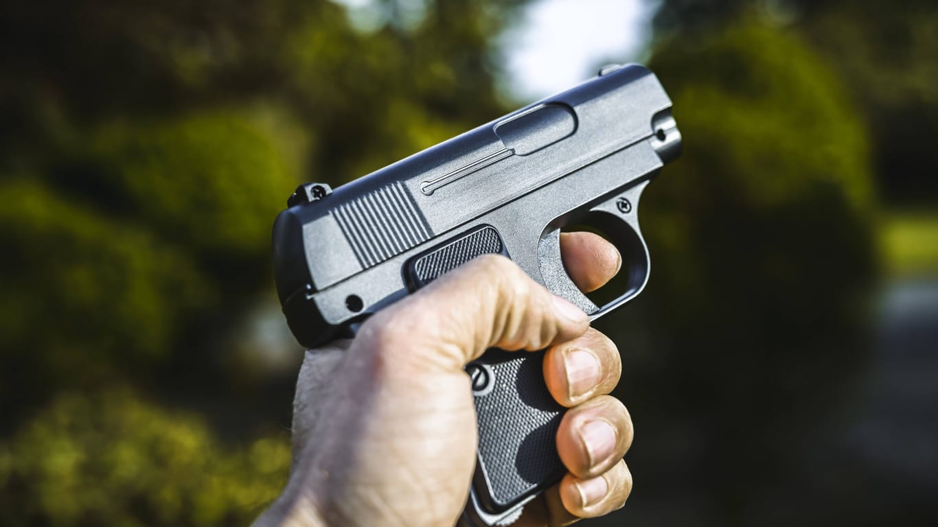 Eine Person hält eine Waffe in der Hand (Archivbild): Auf einem Spielplatz kam es zu einem Polizeieinsatz.