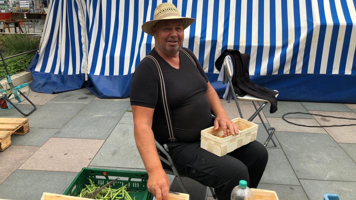 Ein Händler auf dem Rathausmarkt in Kleinmachnow bei Berlin schneidet Pilze