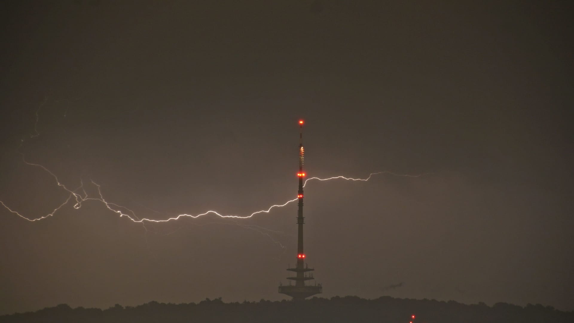 Ein Blitz hinter dem Stuttgarter Fernsehturm: Am Samstagabend zogen Unwetter über Baden-Württemberg.