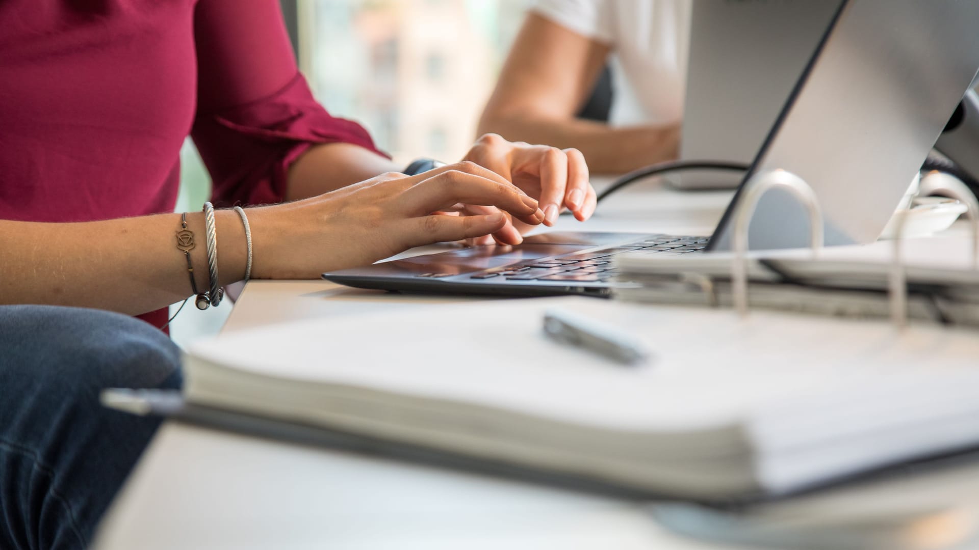 Eine Frau arbeitet am Laptop (Symbolbild): Auch in körperlich wenig anstrengenden Bürojobs kann Berufsunfähigkeit drohen.