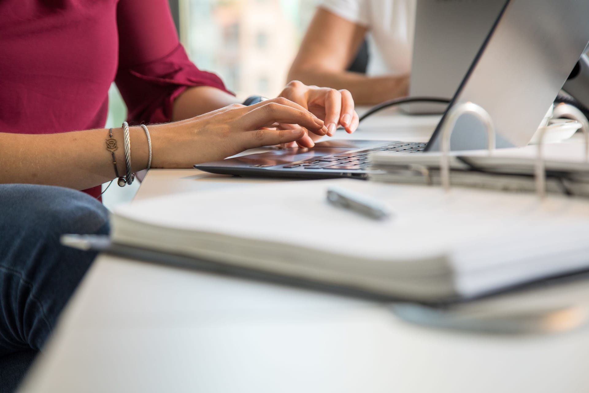 Eine Frau arbeitet am Laptop (Symbolbild): Auch in körperlich wenig anstrengenden Bürojobs kann Berufsunfähigkeit drohen.