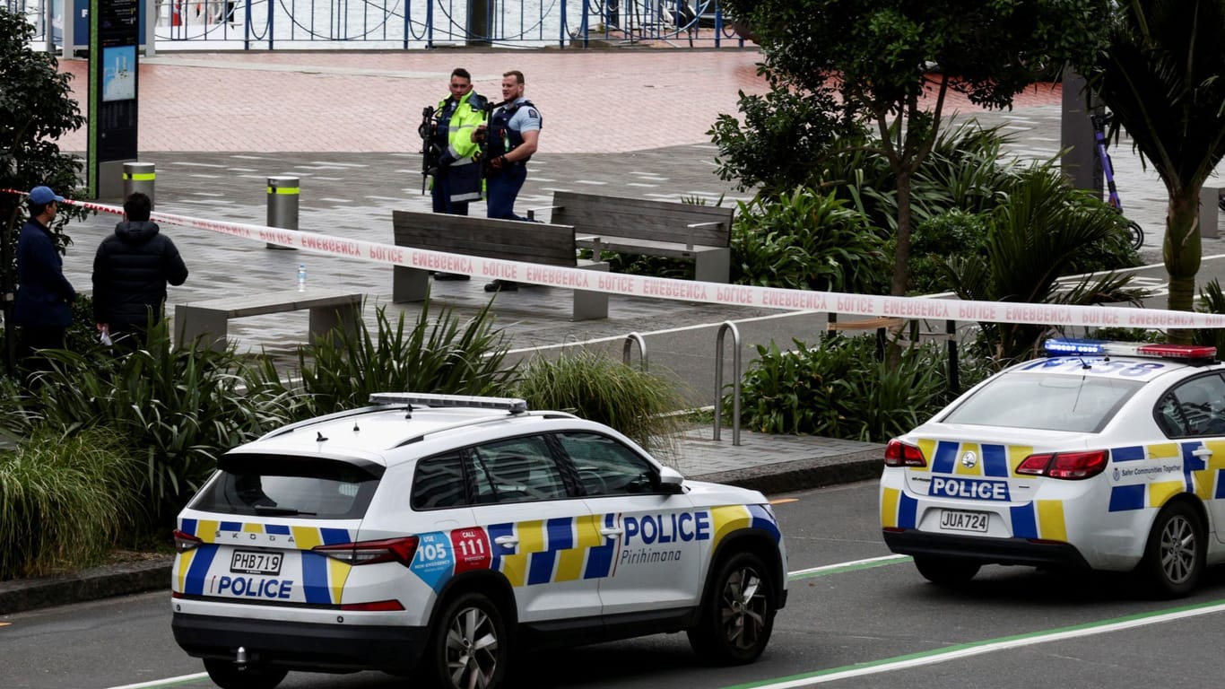 Armed police stand guard near a construction site following a shooting in the central business district, in Auckland
