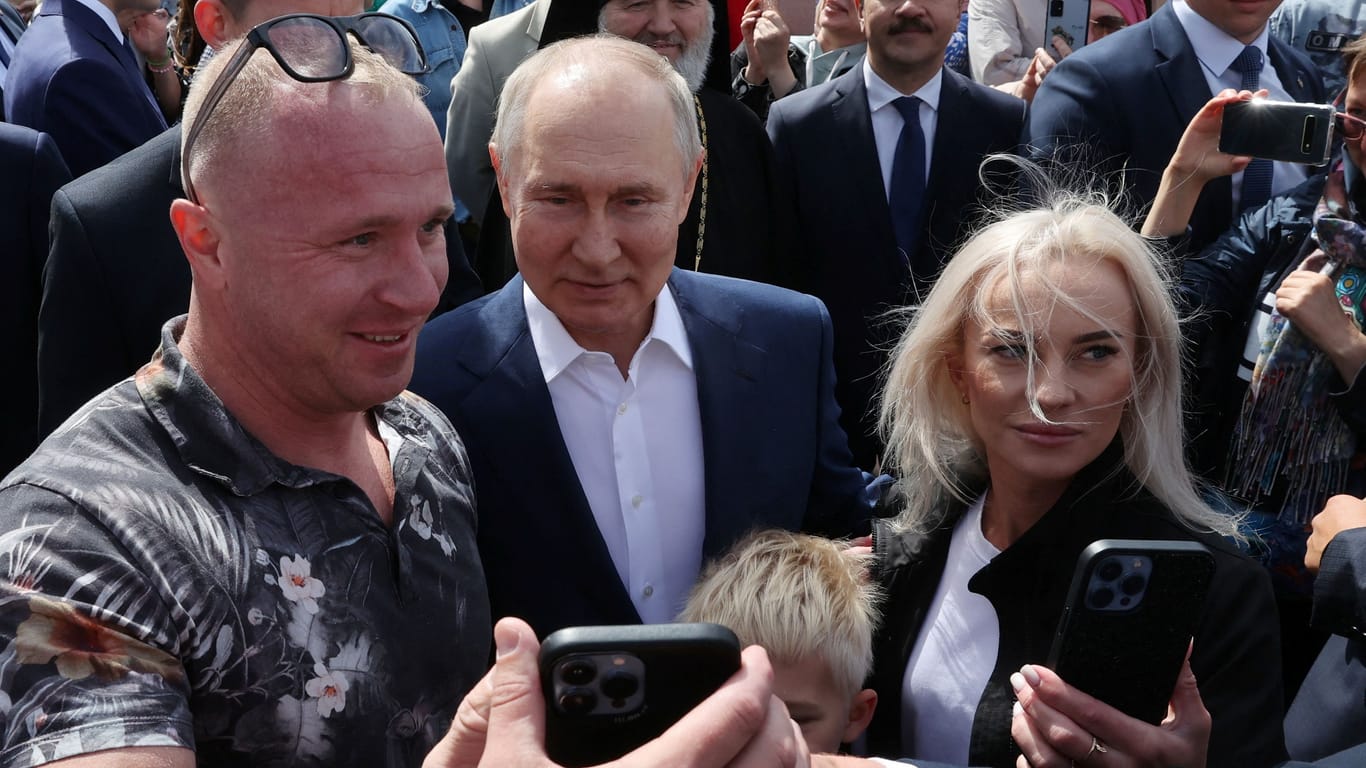 Selfie mit Diktator: Wladimir Putin mischt sich vor der St. Nikolaus-Kathedrale in Kronstadt unter die Leute.