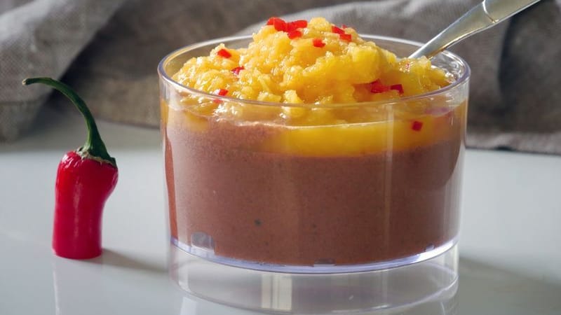 Für die vegane Mousse au Chocolat mit Mango & Chili wird geschmolzene Schokolade vorsichtig unter den Eischnee gehoben und kalt gestellt. Ein Püree aus frischer Mango, Saft und etwas Chili toppt den Schoko-Schnee.