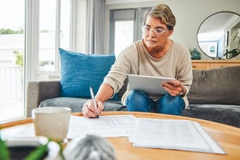 Ältere Frau erledigt ihre Finanzen (Symbolbild): Rentner sind grundsätzlich steuerpflichtig.
