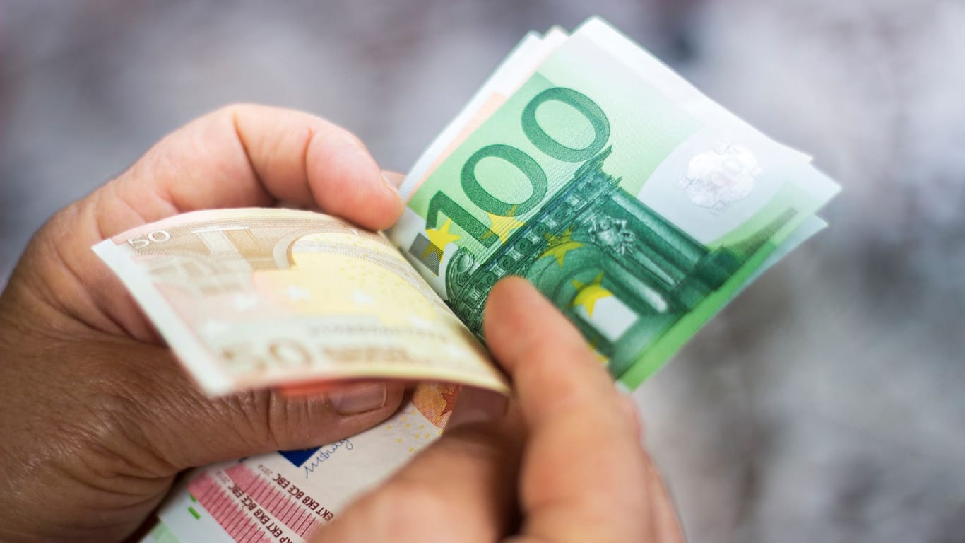 Euroscheine in der Hand: Wer jeden Monat 200 Euro anlegt, kann sich später selbst eine ansehnliche Rente auszahlen.