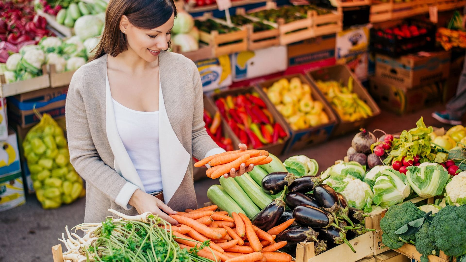 Eine Frau kauft Gemüse: Die Grundlage für einen gesunden Säure-Basen-Haushalt bildet eine vitaminreiche, vorwiegend pflanzliche Ernährung.