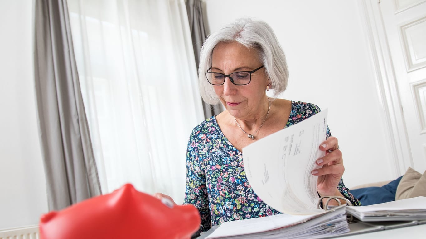 Rentnerin sichtet Unterlagen: Senioren profitieren vom Altersentlastungsbetrag. Bis zum Jahr 2040 wird er aber schrittweise gesenkt.
