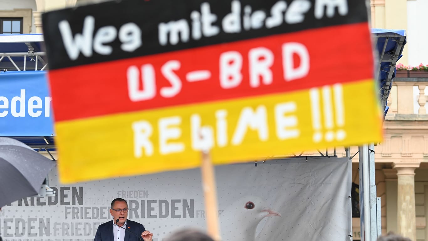 Ein Schild eines AfD-Anhängers bei einer Rede des Parteivorsitzenden Tino Chrupalla in Magdeburg: Die Wählerschaft der AfD gilt als deutlich anfälliger für Verschwörungserzählungen als jene anderer Parteien.