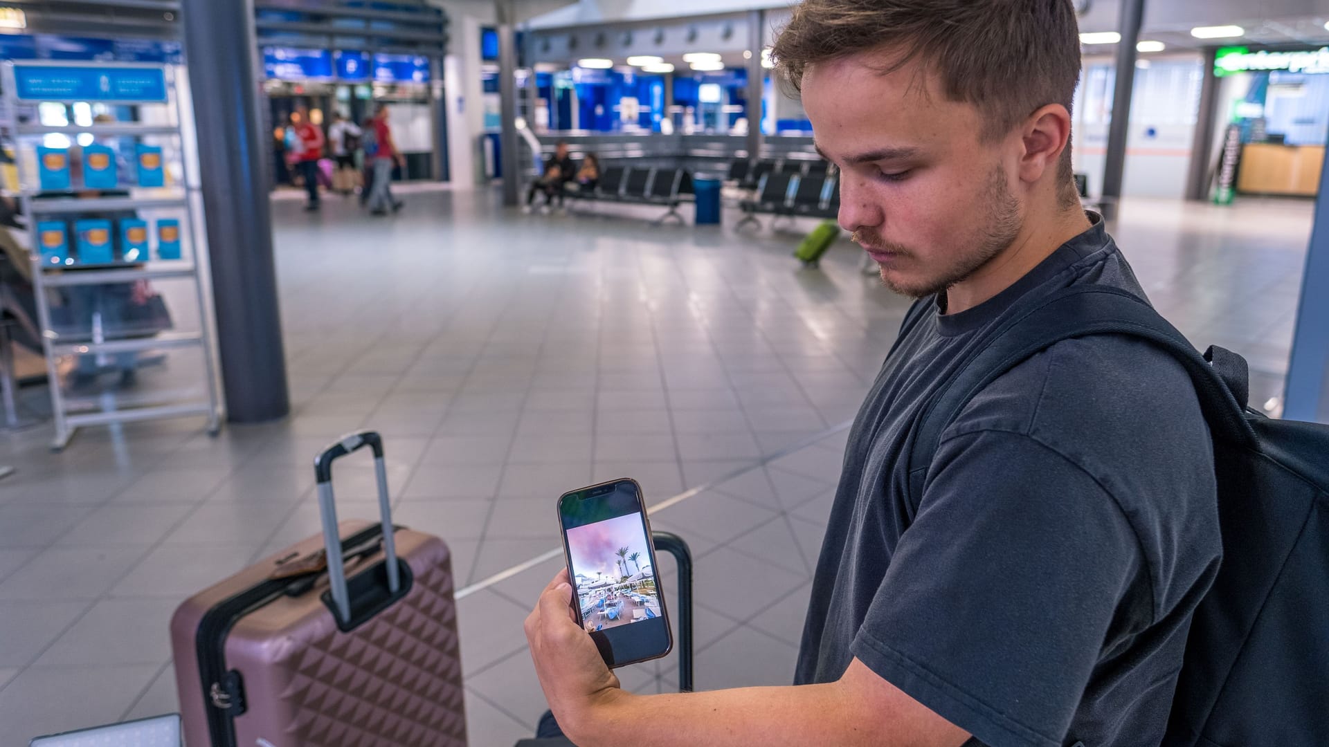 Kilian kehrt aus Rhodos zurück: Am Flughafen Leipzig/Halle zeigt er Bilder von den Rauchwolken.