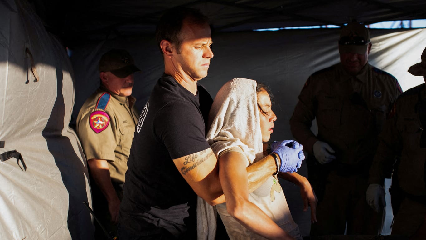 Erste Hilfe wegen der Rekordhitze für Migranten in Texas: Ein Feuerwehrmann trägt eine junge Frau in der Grenzstadt Eagle Pass.