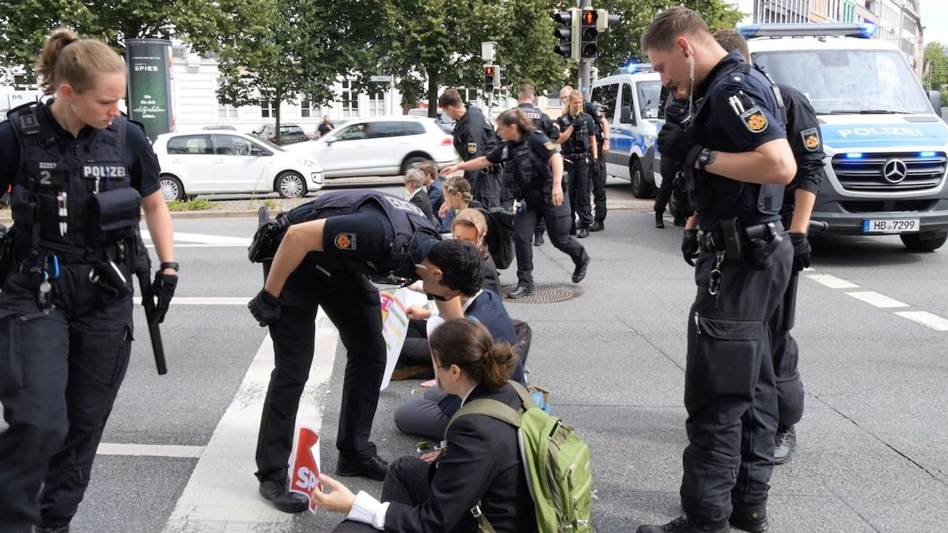Polizisten im Einsatz: In Bremen klebten sich Aktivisten auf die Straße.
