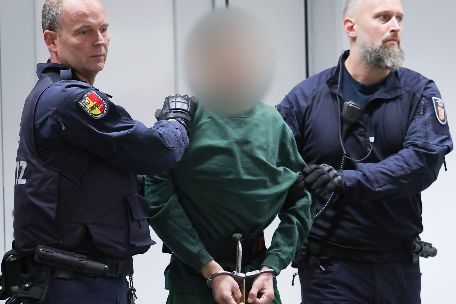 Der Angeklagte wird von Justizbeamten an seinen Platz im Gerichtssaal gebracht: Ibrahim A. muss sich wegen zweifachen Mordes und vierfachen versuchten Mordes verantworten.